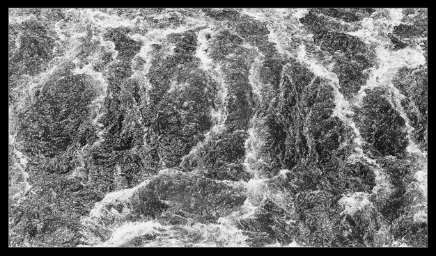 Weißwasser hinter einer Staustufe von direkt oben aufgenommen.
