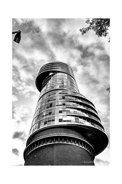 SW Foto. Blick auf eine Hochhaus, das auf einem ehemaligen Bunker errichtet wurde. Die einzelnen Elemente des Hauses sind versetzt angeordnet. Erinnert an eine Kurbelwelle.
