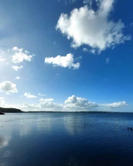 A few white, cotton-wool-like clouds float above the sea against the blue sky. Everything is reflected in the still water. Pure tranquillity. Just let your thoughts drift away. 