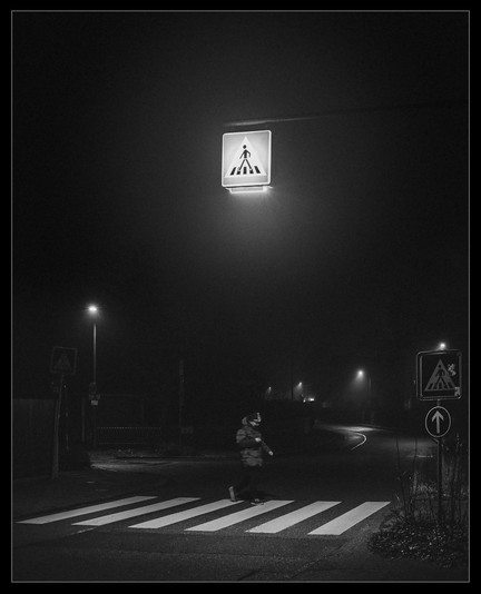 Fußgängerüberweg mit Lampe und Fußgänger.