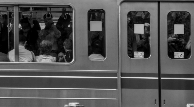 Tren de Tòquio ple de gent que es pot observar des de l'andana i a través de les finestres.