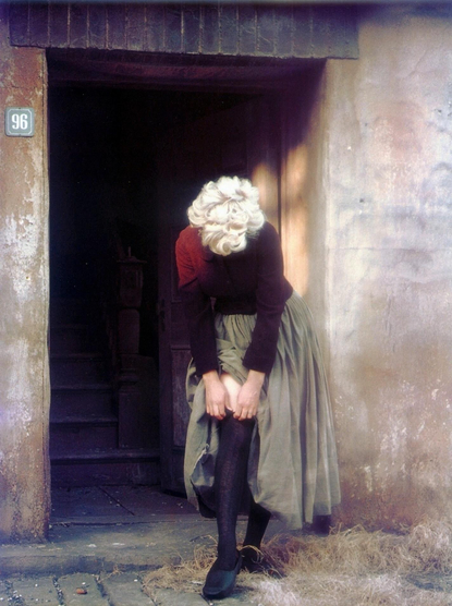 Marilyn enfilant son bas noir sur le pas de la porte du numéro 96