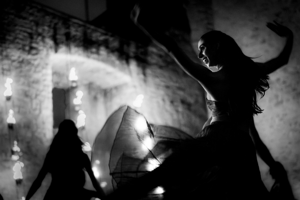 Woman dancer in an medieval castle by night lighted by fire