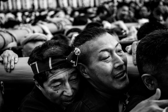 Primer pla en blanc i negre de les cares de portadors del mikoshi a les celebracions del matsuri de Yasukuni a Tòquio.